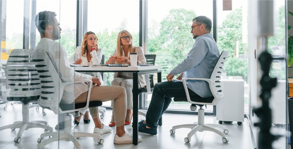 Människor vid ett konferensbord diskuterar kommunikationsstrategi i digitalisering – AI-genererad bild
