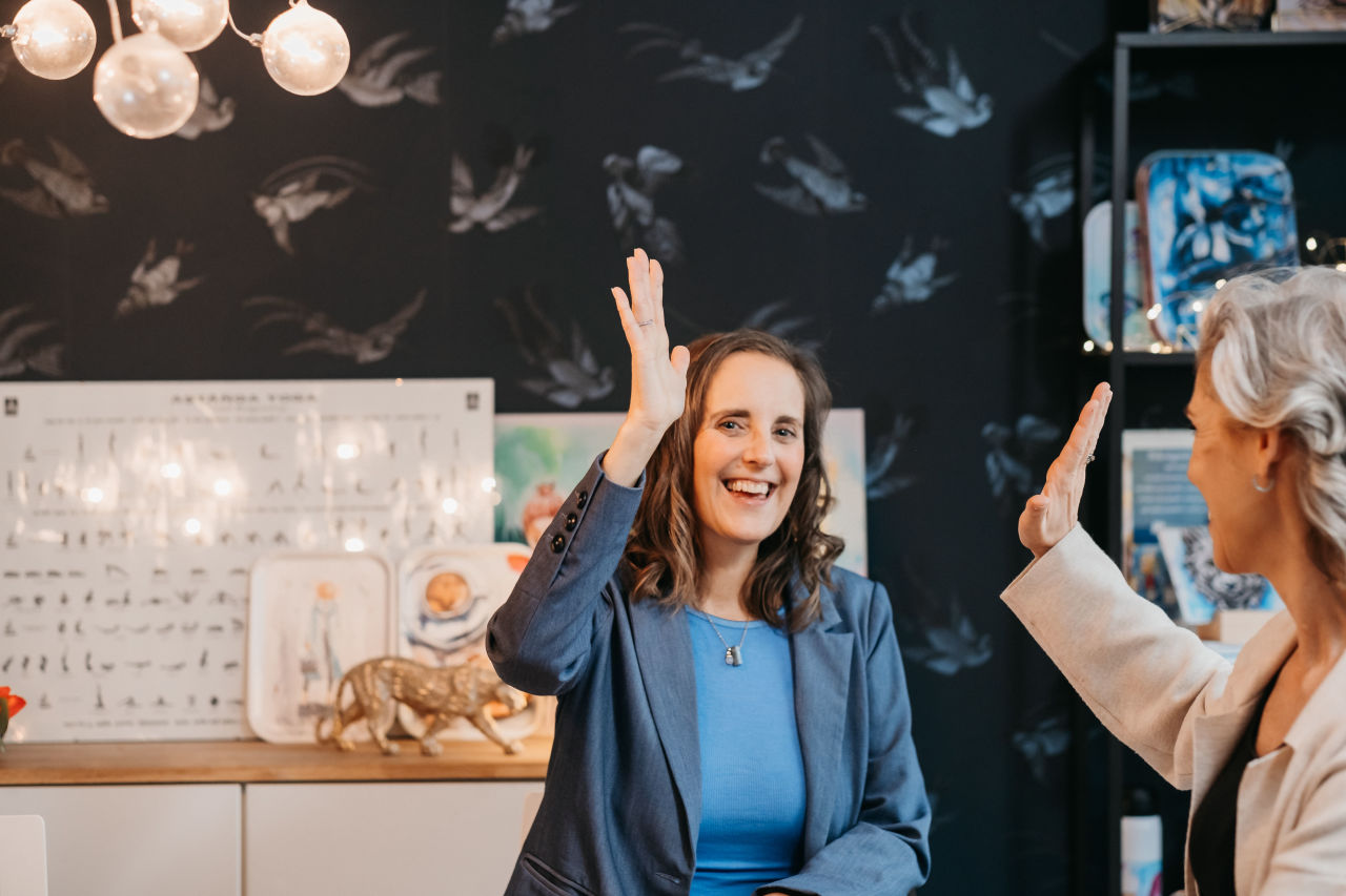 Maria Helgars ger en high five i kreativ arbetsmiljö, artikel om Claude Design som AI-designverktyg. Foto: 360You Photography.